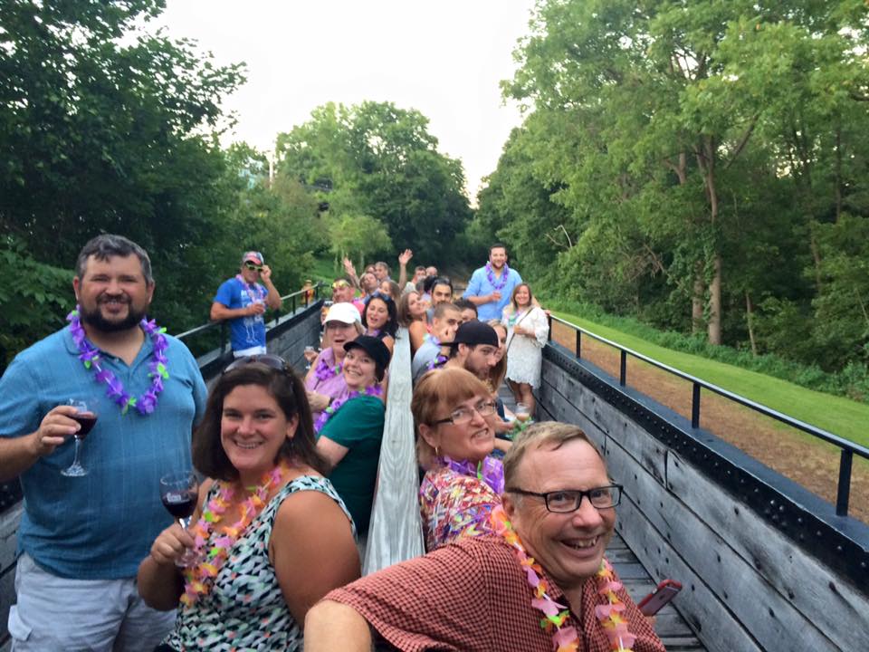 uncovered train car full of passengers on the wine and cheese train